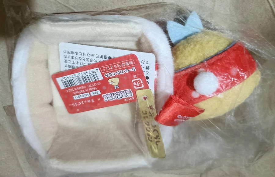2点セットの裏側。とんかつぬいぐるみのタグ（品番MO8990x、©LOTTE ©SAN-X 2024）とひよこキャラのサンタ風コスチュームが確認できる。