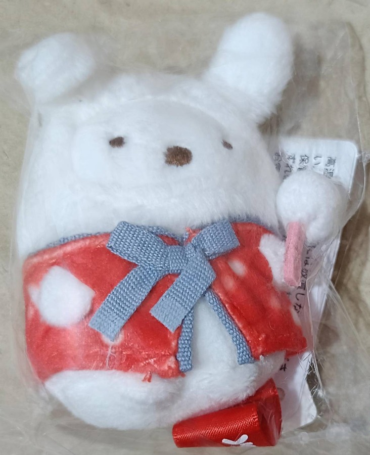 しろくまのてのりぬいぐるみ正面。白いふわふわボディに赤いドット衣装と青リボン、ピンクのアイテムを持つ冬コスチューム仕様。