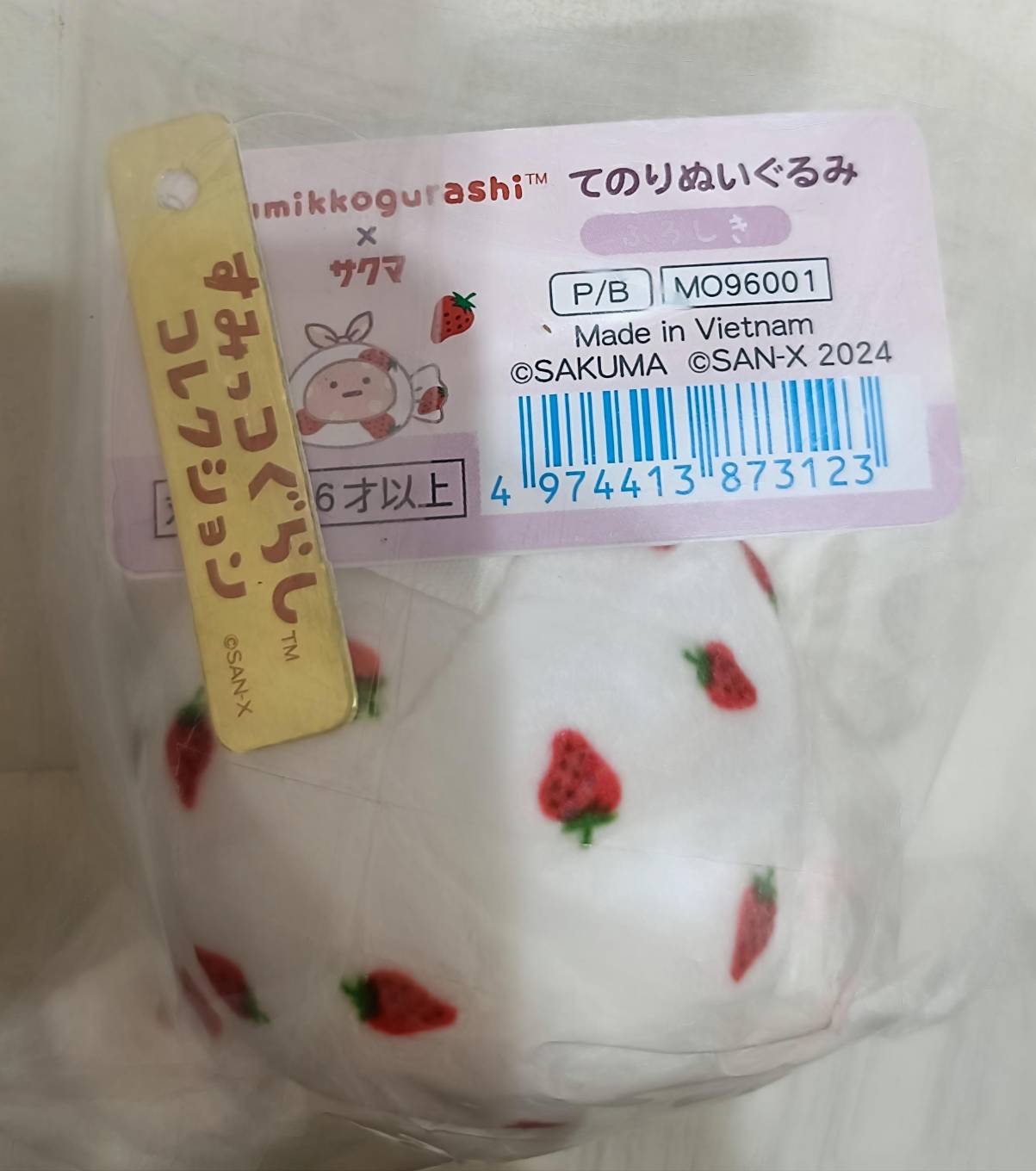 すみっコぐらし×サクマ てのりぬいぐるみ ねこ(品番MO96001)袋入りの状態。いちご柄フード姿のねこのタグが見える。
