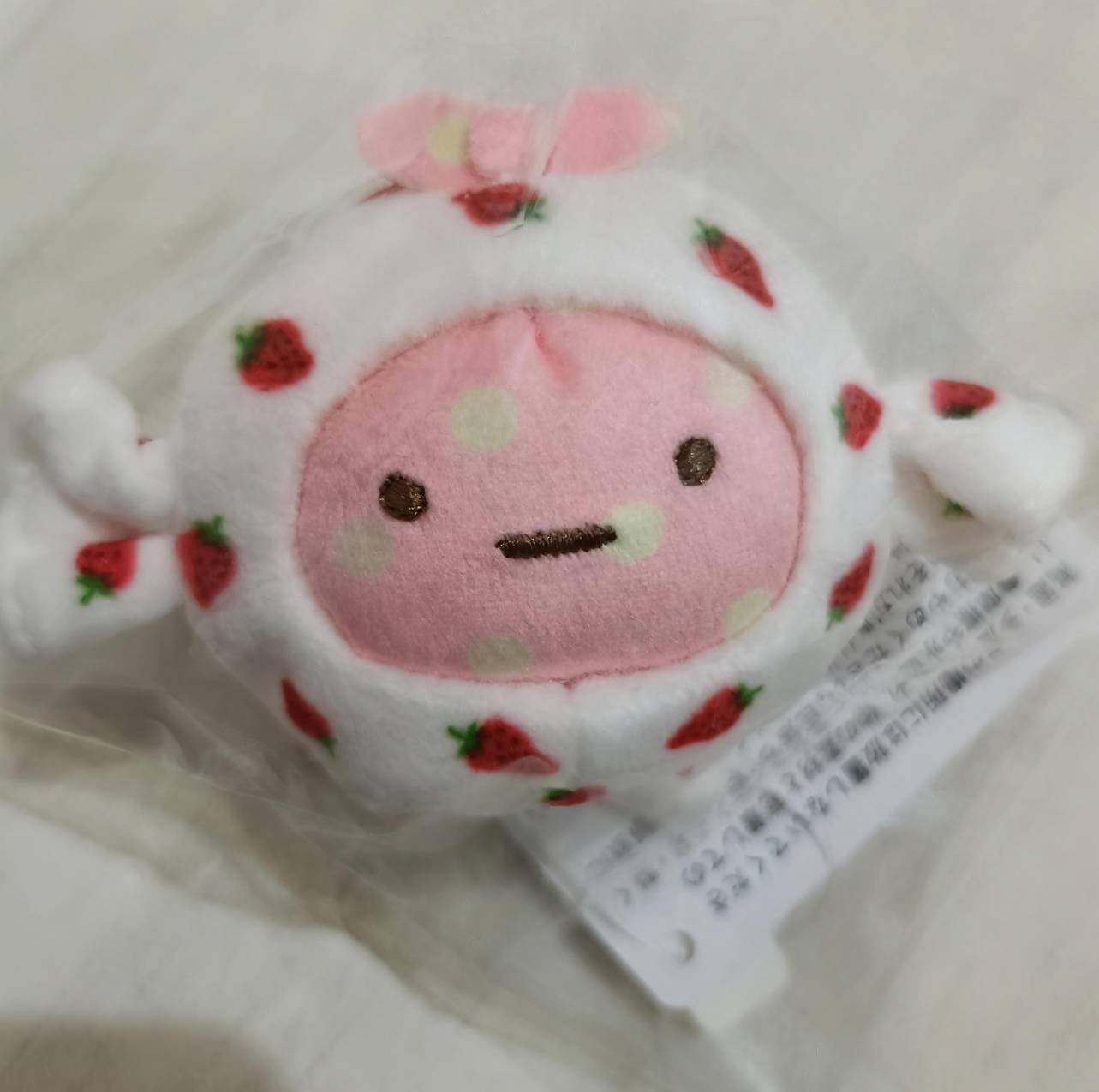 てのりぬいぐるみ ねこ(MO96001)開封後の正面。ピンクのお顔にいちご柄フードとピンクの耳が可愛い。
