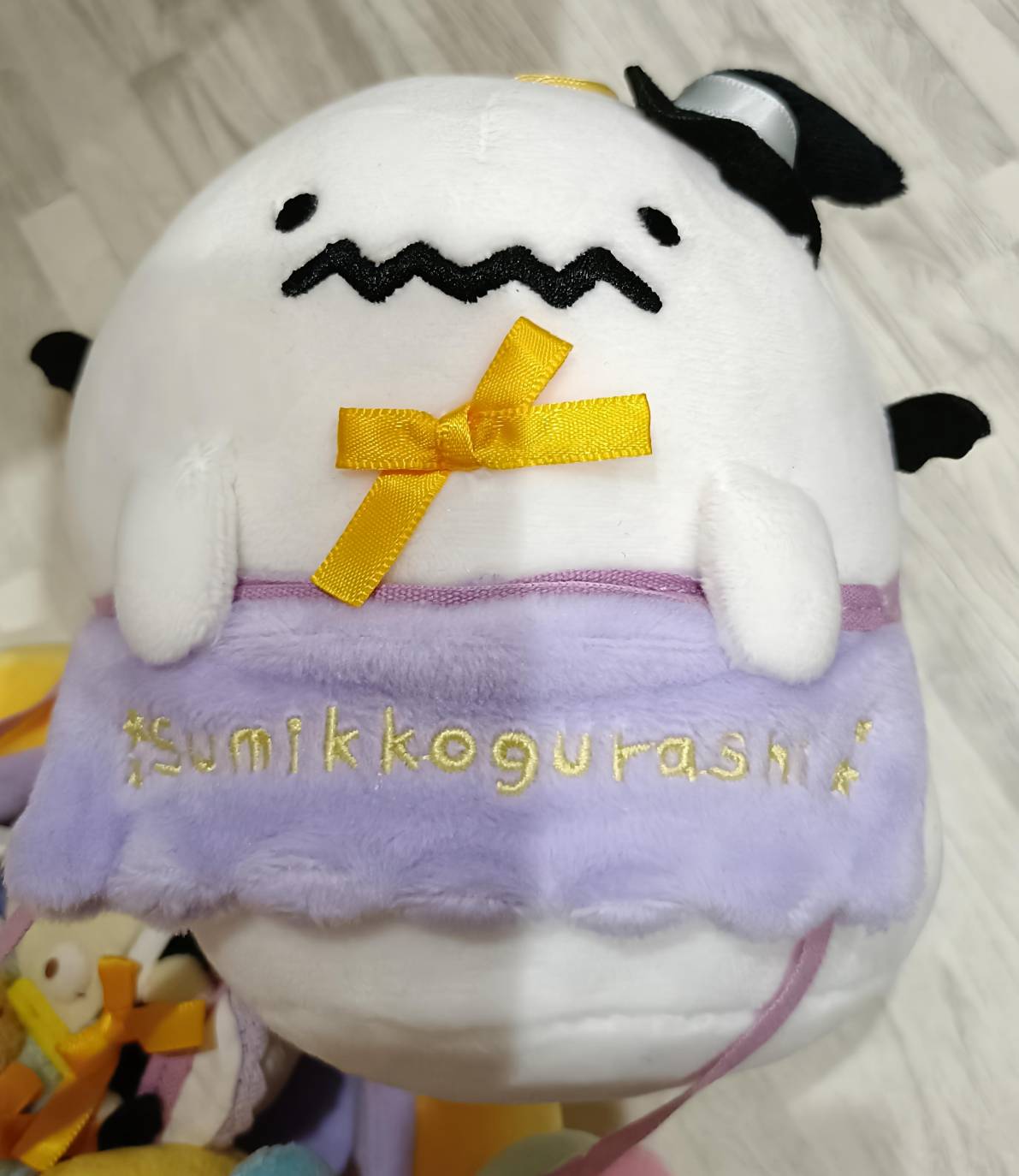 しろくまのおばけぬいぐるみ(かぼちゃふた部分)の正面アップ。黒いジグザグ口・黄色リボン・コウモリ羽根・紫帯の金刺繍が確認できる