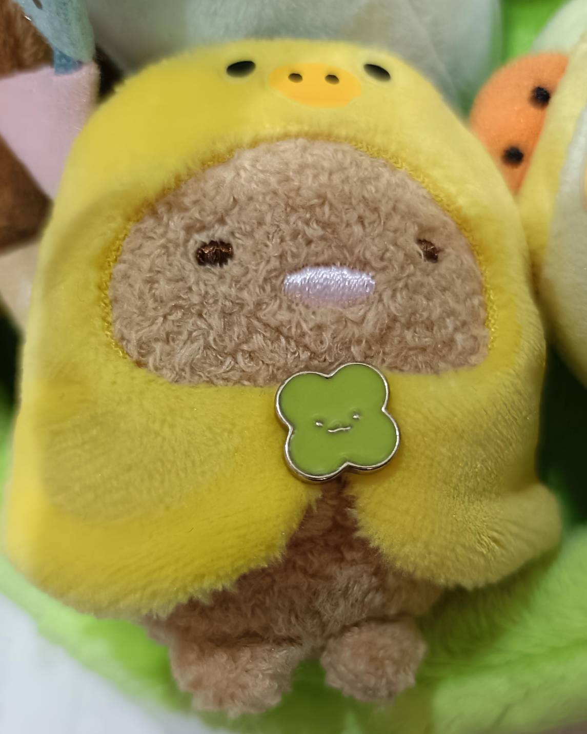とんかつがひよこの着ぐるみを着たマスコット。黄色いひよこ頭からとんかつの顔が覗く、緑のクローバーチャームあり