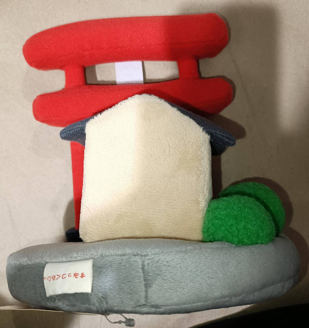 すみっコぐらし神社 シーンぬいぐるみの背面。白いお社・グレー台座・緑の木オブジェ・裏タグが確認できる。