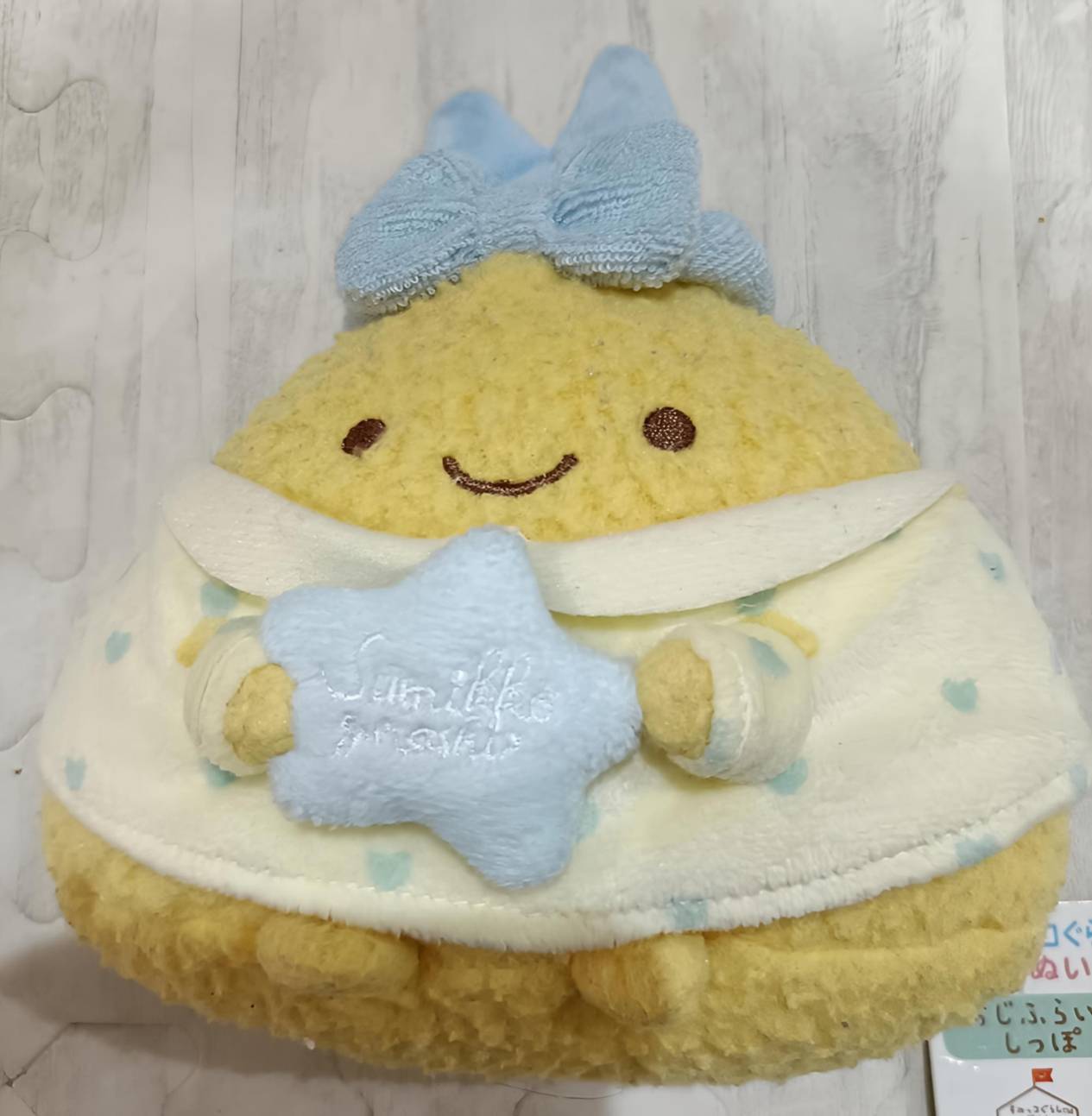あじふらいのしっぽ ぬいぐるみ 正面アップ。刺繍の顔と「Sumikko gurashi」ロゴ入りの星ぬいぐるみが確認できる。