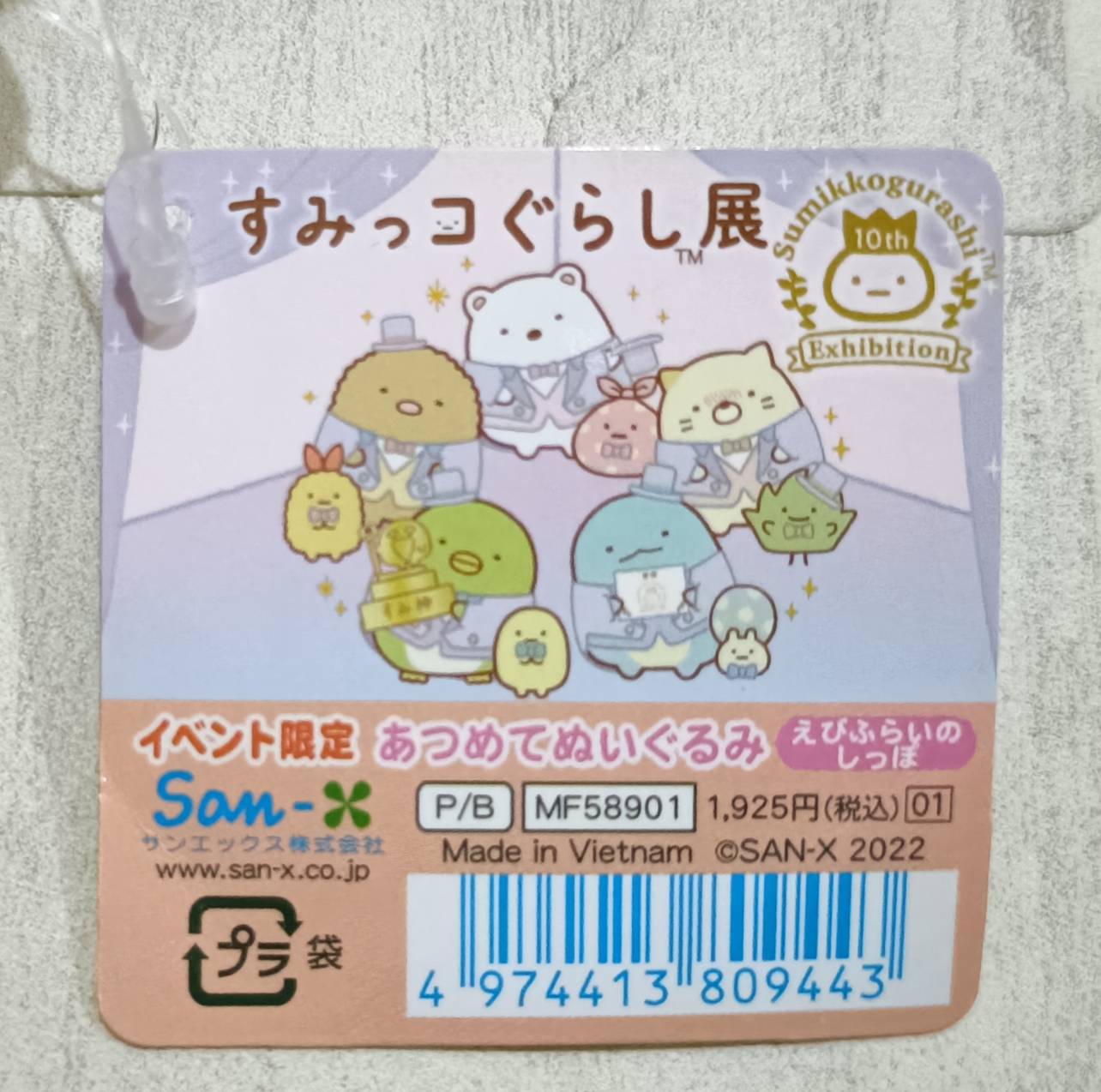 すみっコぐらし展 10周年記念タグ正面。品番MF58901、1,925円（税込）、イベント限定・あつめてぬいぐるみ・えびふらいのしっぽと記載。